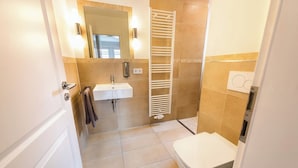 A bathroom with a white sink, a toilet, and a towel rack.