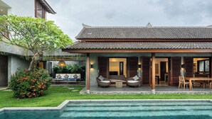 A traditional-style house with a swimming pool in the foreground.