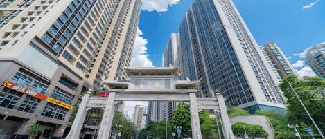 A city intersection with tall buildings, a traditional archway, and a crosswalk.