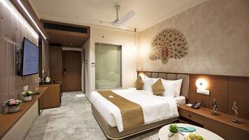 Una habitación de hotel moderna con una cama grande, mesita de noche y un elemento decorativo con la figura de un pavo real.