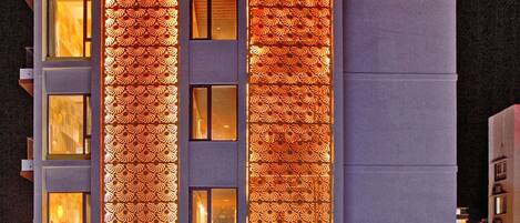 A hotel with a modern facade, large windows, and a prominent vertical light display.