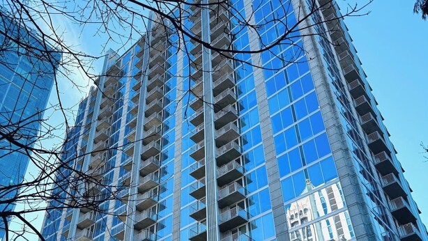Un immeuble de grande hauteur doté de nombreux balcons et de grandes fenêtres.