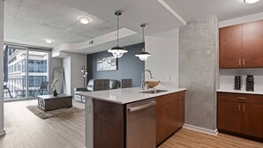 Una cocina moderna con una isla central, armarios de madera e iluminación colgante.
