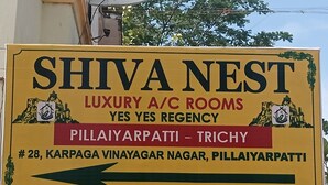 Tässä on kyltti hotelli Shiva Nestille, joka on ylellinen, ilmastoinnilla varustettu hotelli. Hotelli sijaitsee osoitteessa: 28, Karpaga Vinayagar Nagar, Pillaiyarpatti, Trichy.
