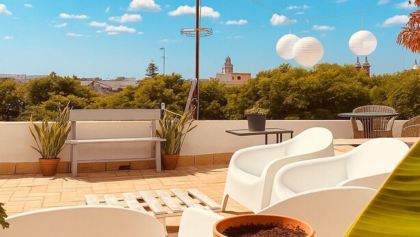 A rooftop terrace with white chairs, a table, and a potted plant. - Cozy Penthouse in the center. Air conditioning (Jerez de la frontera)