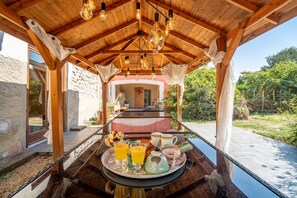 Un desayuno con una bandeja de comida y bebidas, techo de madera y vista al exterior.