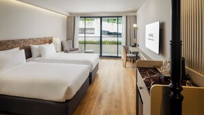 Een hotelkamer met twee bedden, een bureau, een stoel en een televisie.