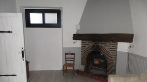A room with a fireplace, a wooden chair, and a white door.