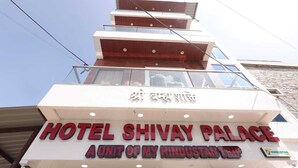 Une enseigne d’hôtel portant le nom « Hotel Shivay Palace » et le slogan « Un établissement du groupe My Hindustan Trip ».