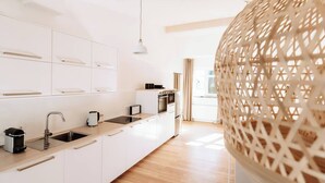 A modern kitchen with white cabinetry, a stainless steel sink, and a built-in oven. - 06 Deichstadt-Apartments Neuwied  104m² (Neuwied)