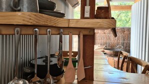 Una cuina rústica amb prestatgeries de fusta plenes de recipients i utensilis de cuina.
