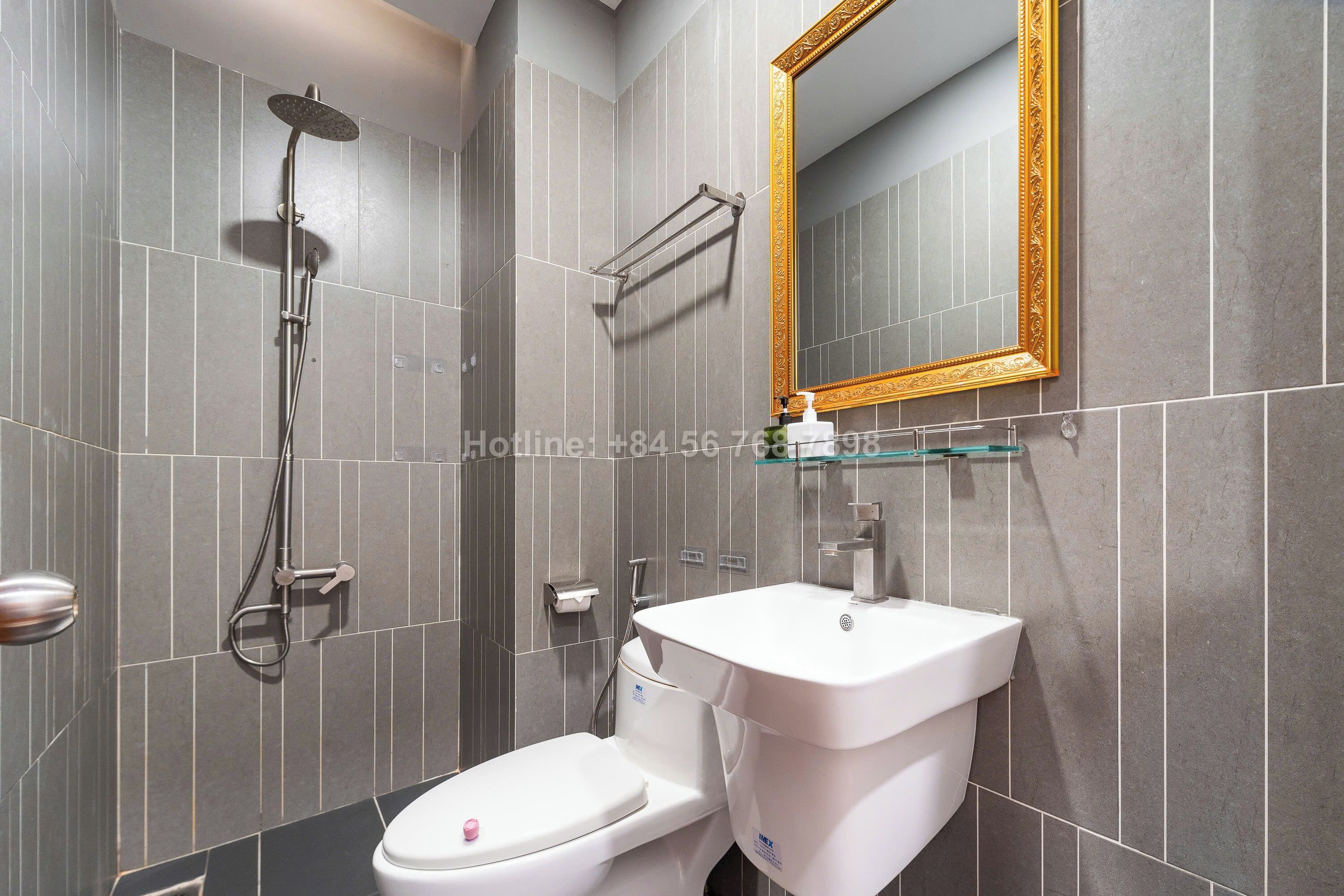 A modern bathroom with a toilet, sink, and shower.