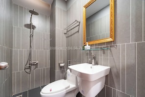 A modern bathroom with a toilet, sink, and shower. - TagoAmber (Ho Chi Minh City)