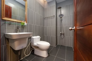 A modern bathroom with a toilet, sink, and shower.