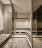 Een moderne, minimalistische kamer met ingebouwde banken en een centraal rek.
