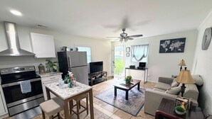A modern kitchen with stainless steel appliances, a dining area with a marble table, and a living room with a sofa and a coffee table. - Renovated 2 Bedroom  in Durham!  New listing but experienced Superhost! (Durham)