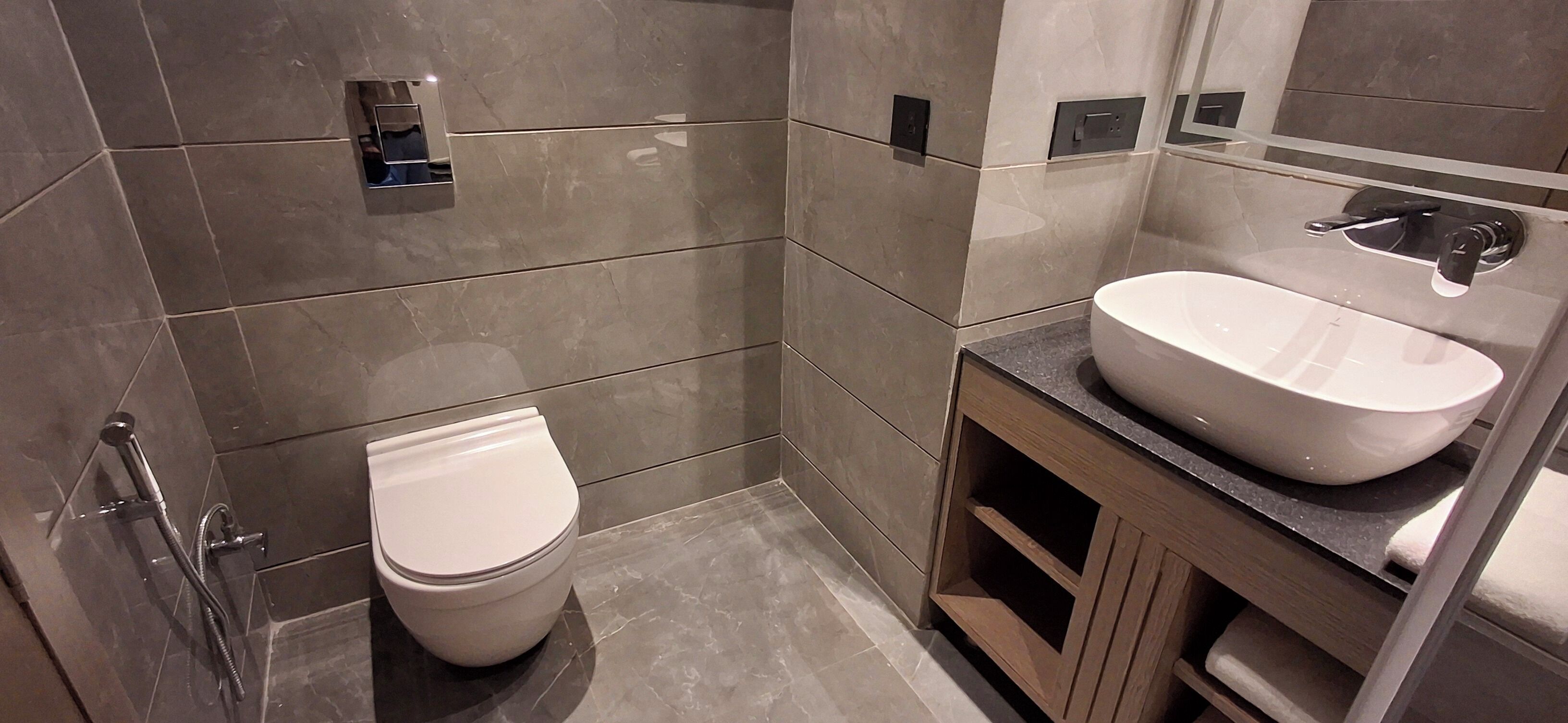 A modern bathroom with a toilet, a sink, and a shower.