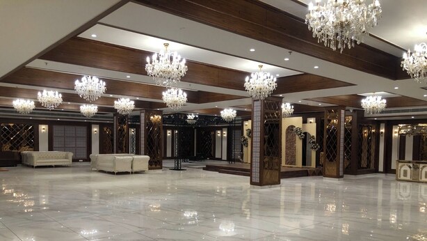 A spacious lobby with marble flooring, multiple chandeliers, and seating areas. - Rosastays Hansi (Hansi)