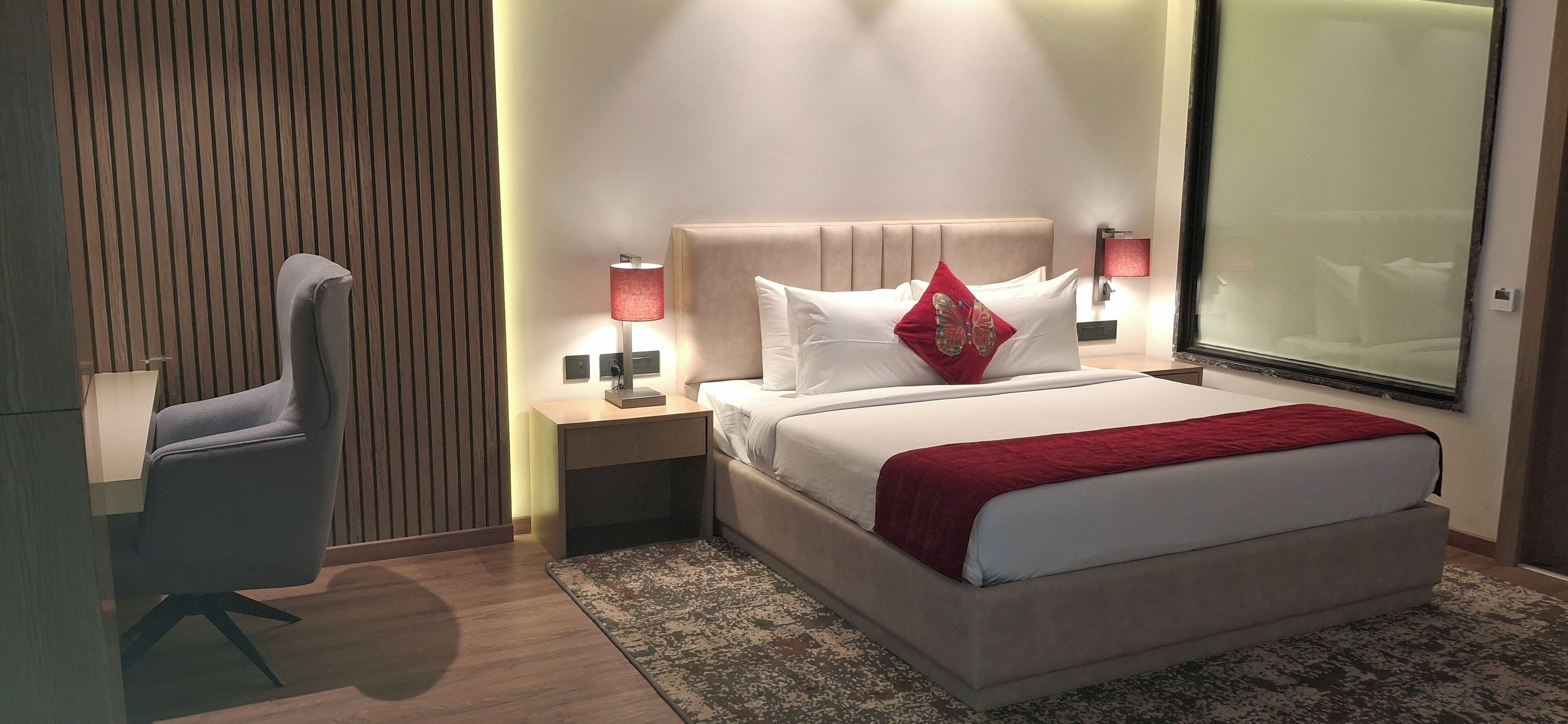 Une chambre d’hôtel moderne, dotée d’un grand lit, d’un bureau et d’une chaise.