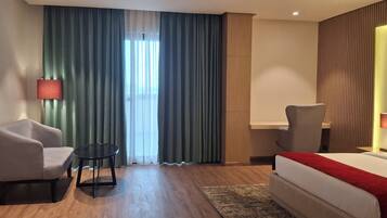 Deluxe tweepersoonskamer | Een kluis op de kamer, een bureau, verduisterende gordijnen