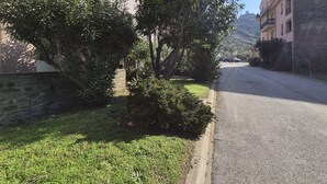 A residential street with houses on both sides, a clear sky, and a hilly landscape in the background. - Collioure T2 Apartment with Terrace and Parking (Collioure)