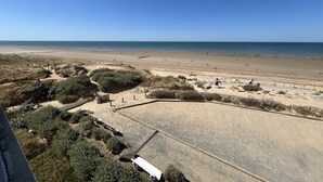 A beach with a clear sky, sandy shore, and a few people. - 2-room apartment with sea-facing balcony - Saint-Hilaire-de-Riez (Saint-Hilaire-de-Riez)