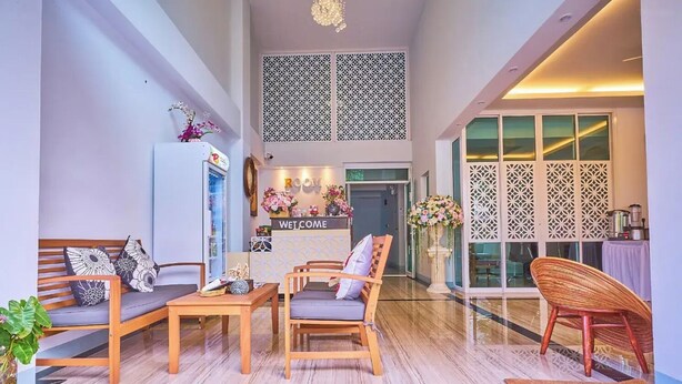 A spacious living area with a sofa, chairs, a coffee table, and a reception desk with a 'WELCOME' sign. - Belvilla Chiangmai near Lanna Hospital (Chiang Mai)