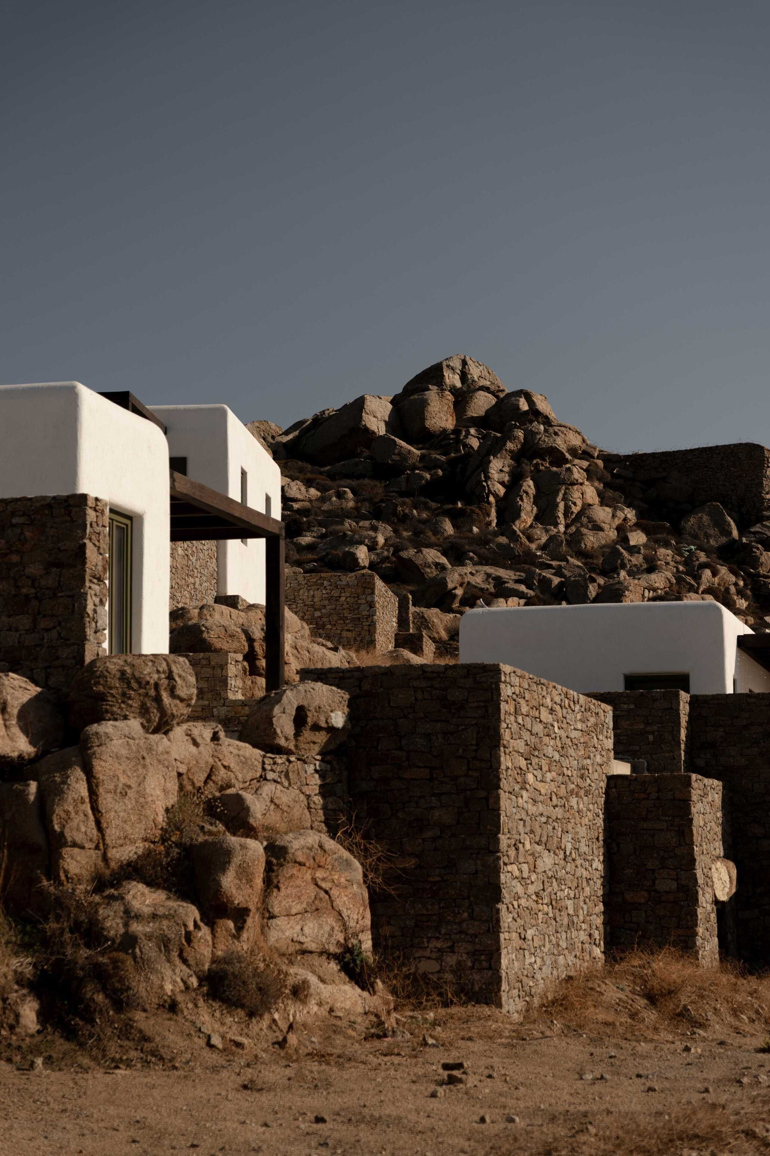 A stone building with a white facade, a door, and a small window.