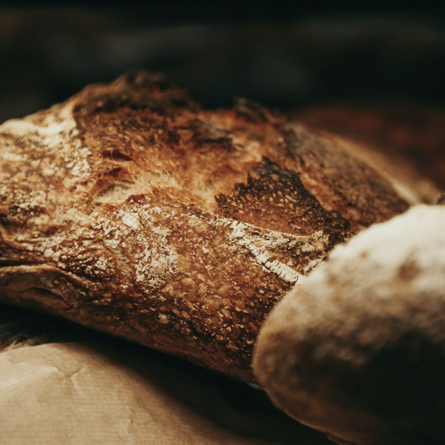 A loaf of bread with a crusty exterior, placed on a surface.