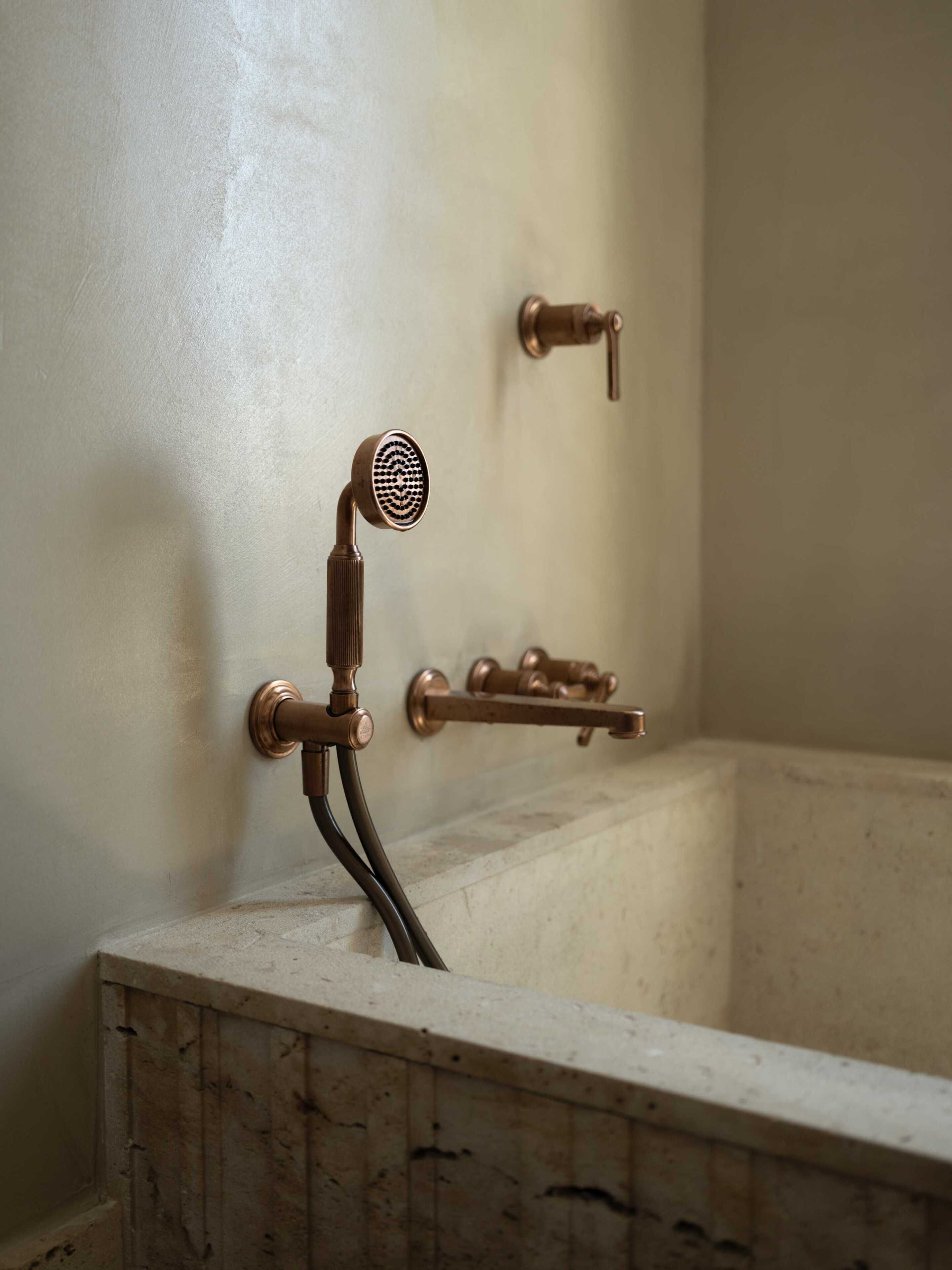 A bathtub with a showerhead, a towel rack, and a wall-mounted faucet.