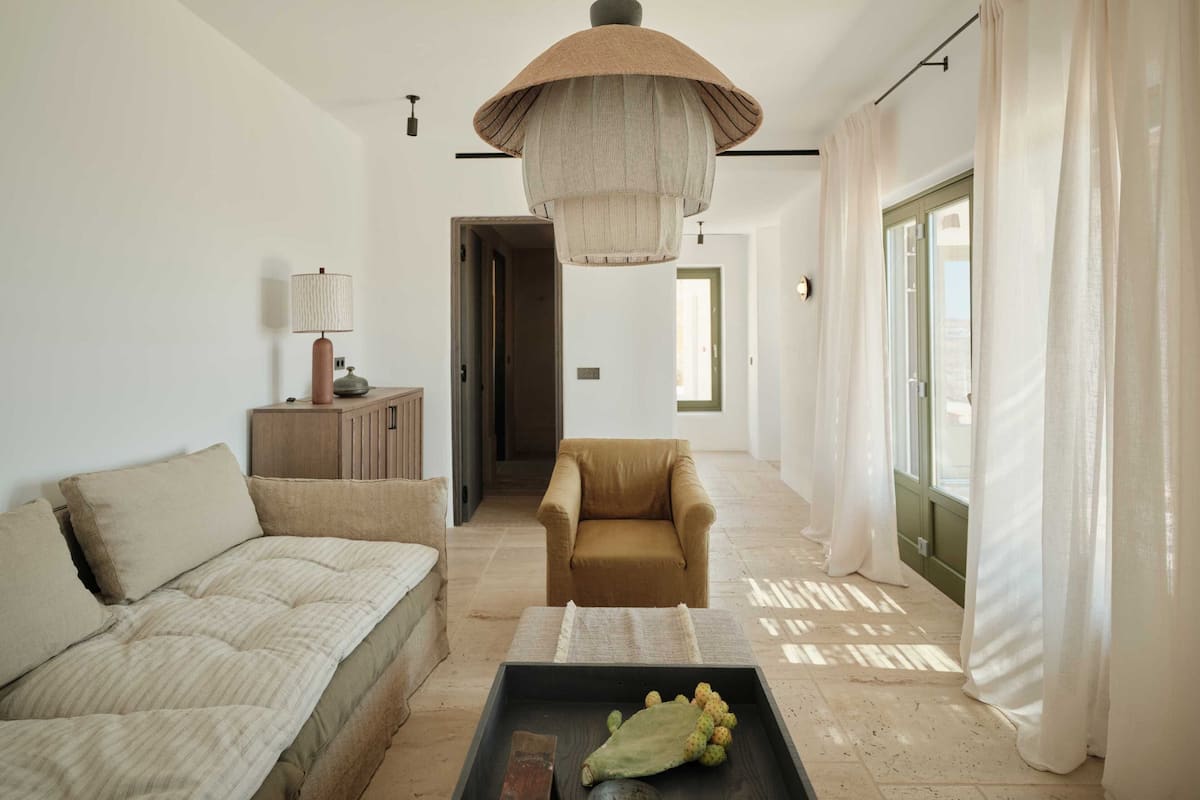 A modern living room with a sofa, armchair, and a coffee table.