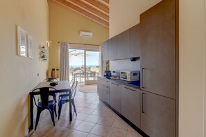 Una cucina con tavolo e sedie, un frigorifero e vista sull'esterno.