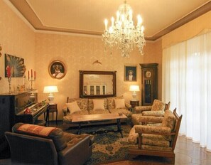 A classic living room with a chandelier, a sofa set, a coffee table, and a fireplace. - Butterfly Apartment In Lucca (Lucca)