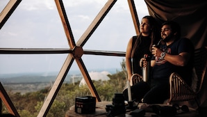 A room with a large window offering a view of the outdoors. There is a wooden table with various items on it. - Piedra de las Animas (Nueva Carrara)