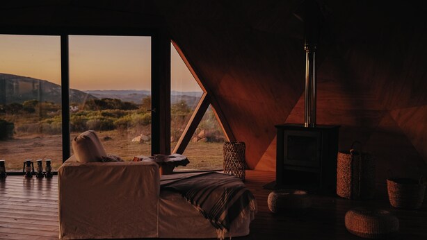 A cozy room with a bed, a fireplace, and a view of the outdoors. - Piedra de las Animas (Nueva Carrara)
