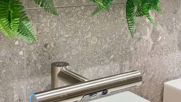Un baño con un grifo moderno, un lavabo y un espejo.