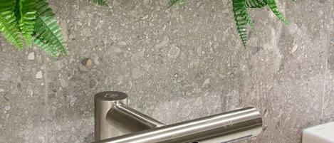 A bathroom with a modern faucet, a sink, and a mirror.