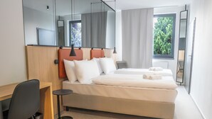 Een moderne hotelkamer met een groot bed, een bureau en een stoel.
