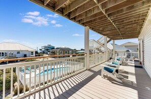 A wooden deck with a pool and lounge chairs, overlooking a residential area. - Makin' Memories 4 BR 4.5 Bath Home w/Private Pool, Elevator and Hot Tub (St. George Island)
