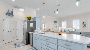 A modern kitchen with a large island, white cabinetry, and pendant lighting. - Makin' Memories 4 BR 4.5 Bath Home w/Private Pool, Elevator and Hot Tub (St. George Island)