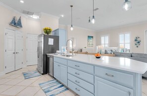 A modern kitchen with a large island, white cabinetry, and pendant lighting. - Makin' Memories 4 BR 4.5 Bath Home w/Private Pool, Elevator and Hot Tub (St. George Island)