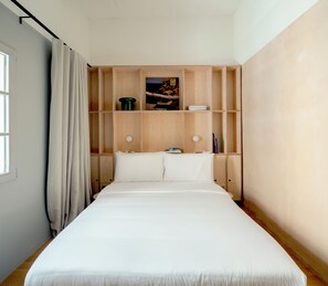 A bedroom with a bed, wooden shelving, and a window with curtains. - Stilla, 6, Triq San Lazzru (Cospicua)