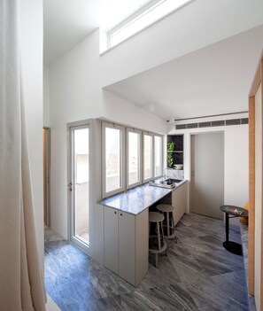 Studio, balkon | Privékeuken | Een minikoelkast, een kookplaat, kookgerei, borden en bestek
