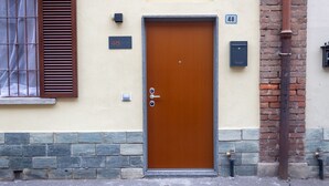 Une porte marron avec une serrure, une boîte aux lettres et une plaque indiquant le numéro de l’adresse : 48.