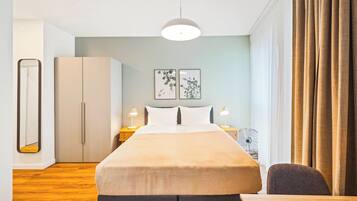A modern hotel room with a large bed, bedside tables with lamps, a wardrobe, and a view of the outdoors.