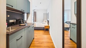 Una cocina moderna con gabinetes oscuros, un lavamanos de acero inoxidable y una cafetera.