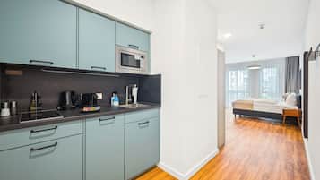 A modern kitchen with light blue cabinets, a microwave, and a coffee maker.