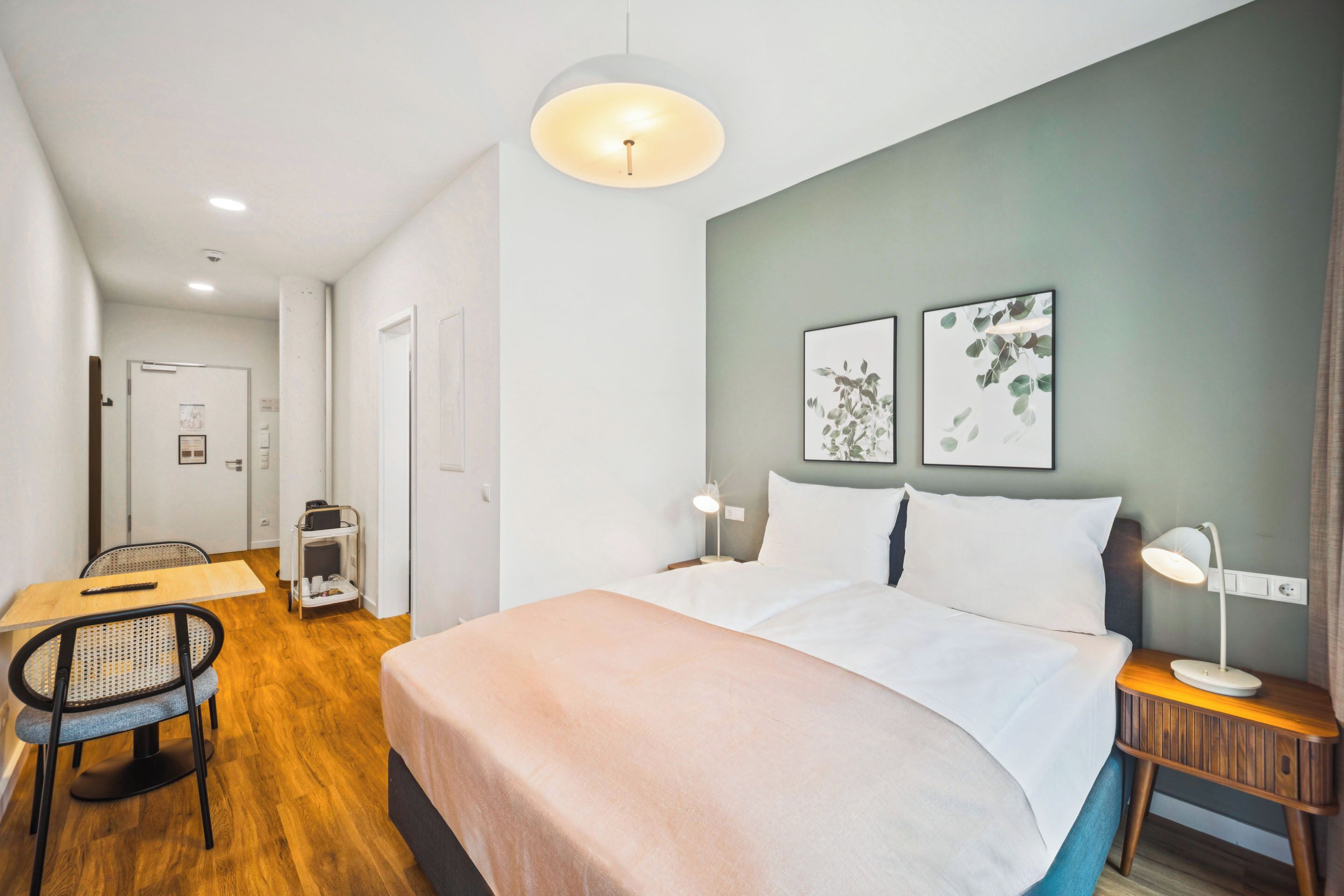 Una habitación de hotel con cama, mesitas de noche, escritorio y una silla.