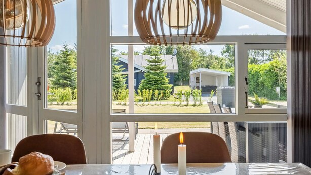Un espace repas comprenant une table, des chaises et une bougie.