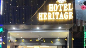 La entrada del Hotel Heritage, con una recepción, una estatua de Buda y una escalera que lleva al vestíbulo.